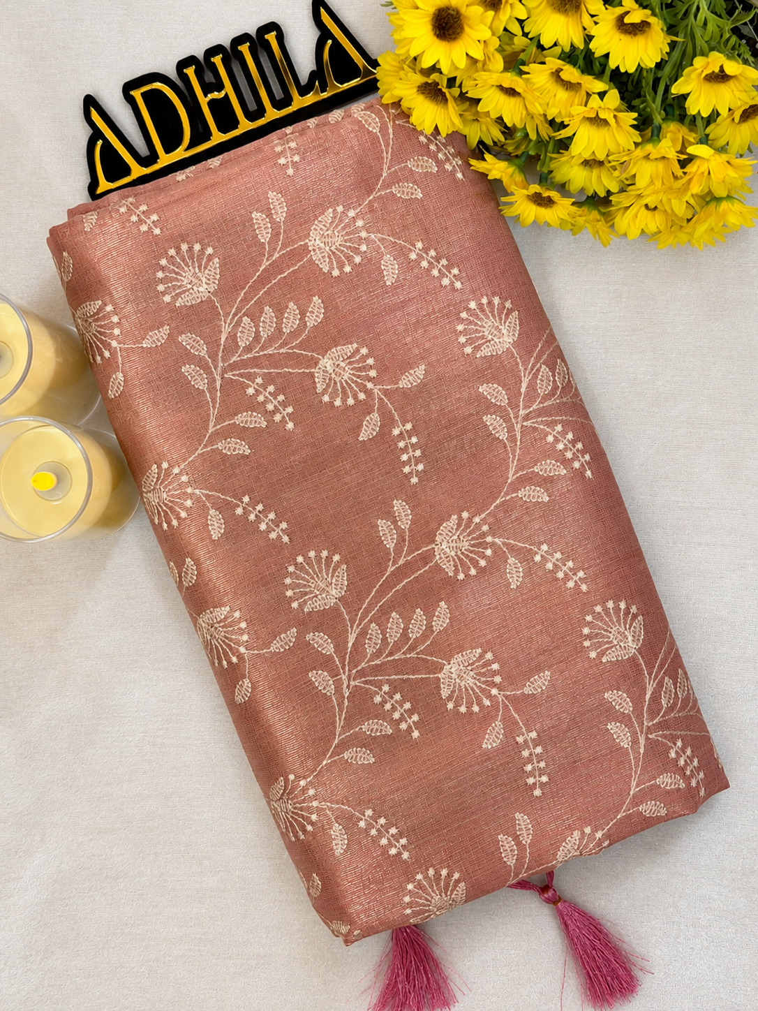 Dusty Rose Pink Floral Tissue Saree – folded view showing floral Jaal work and tassels