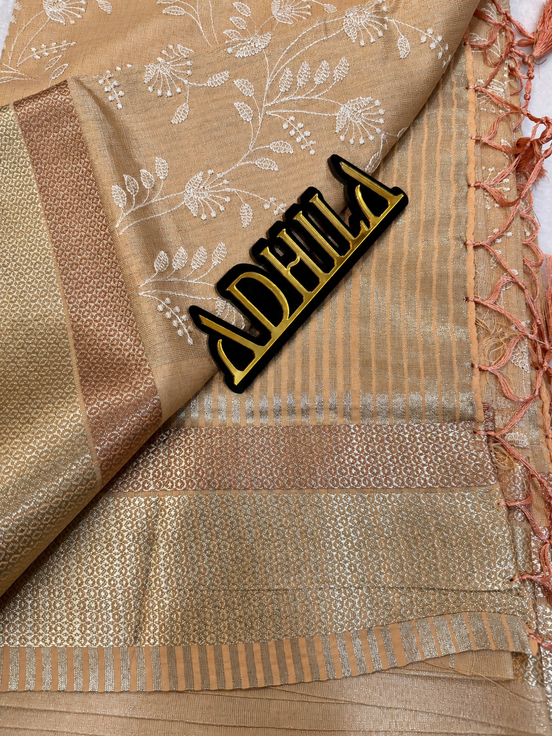 Terracotta Orange Floral Tissue Saree – unfolded view showing zari border and Adhila logo