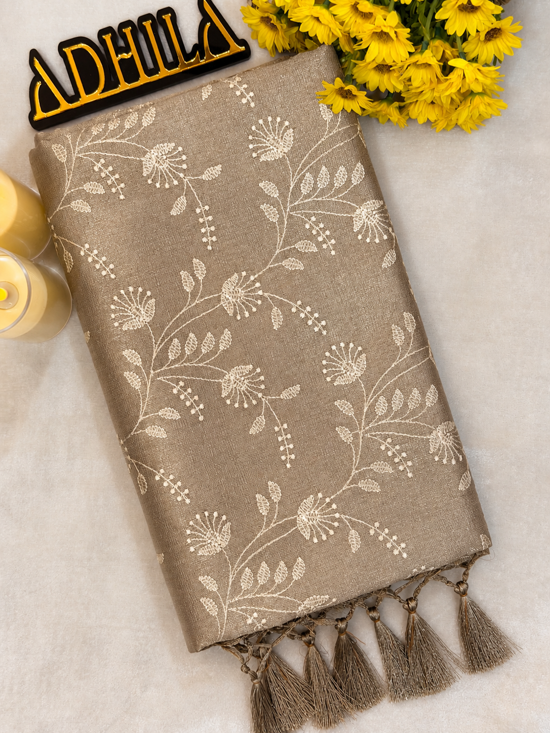 Grey Floral Tissue Saree – folded view showing floral Jaal work and coordinated grey tassels