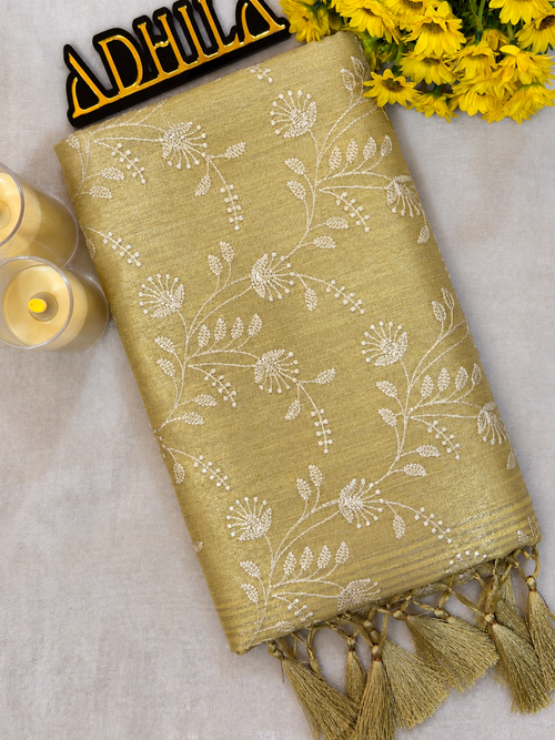 Golden Yellow Floral Tissue Saree – folded view showing floral Jaal work and golden tassels with Adhila logo
